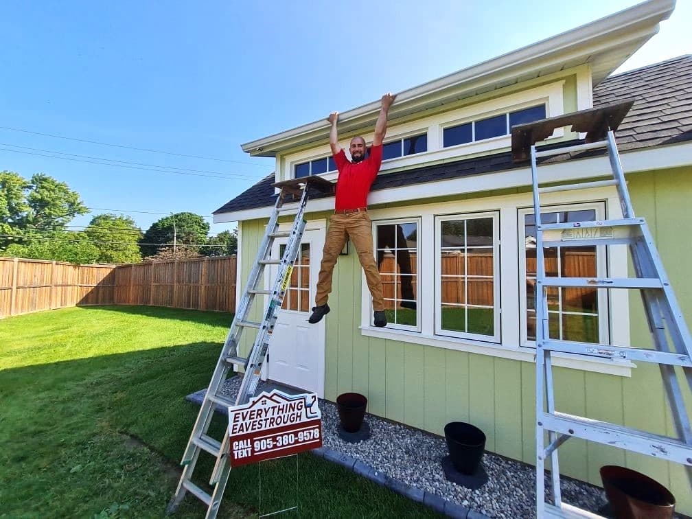Everything Exteriors Inc. crew member installing eavestrough on a greenhouse